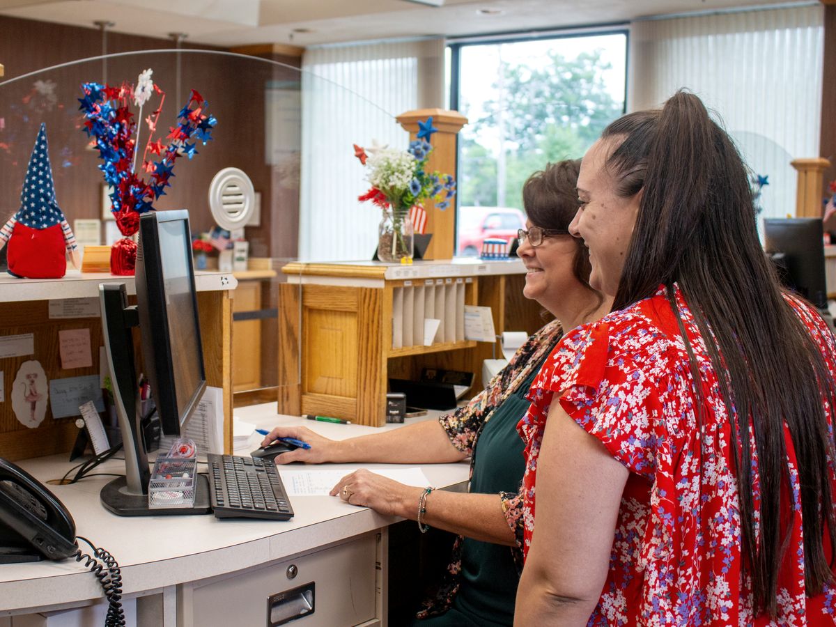 A teller helping a customer at the Greenville Main Office counter