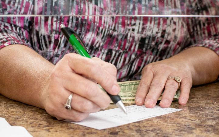 A customer signing paperwork with a Greenville Savings Bank pen
